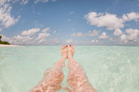 The feet of a woman in a transparent oceanの写真素材