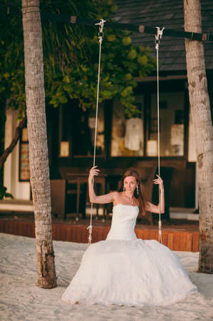 The beautiful bride on a swing on the islandの写真素材