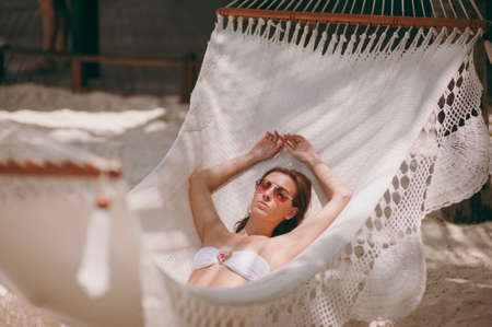 The beautiful girl lies in a hammock on the beachの写真素材