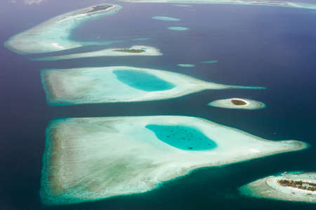 The tropical islands and atolls in Maldives in Indian Ocean from aerial view. Piece of paradise on the Earth. Good choice for vacation. Beautiful top view for wallpaper.の写真素材