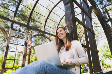 Young successful businesswoman in light casual clothes. Woman working on modern laptop pc computer,...