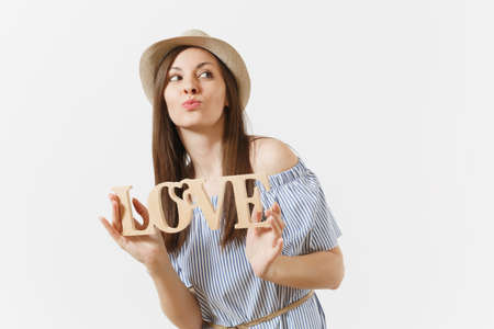 Young woman in blue dress, hat holding wooden word love isolated on white background. St. Valentine's, International Women's Day holiday. People, sincere emotions, lifestyle concept. Advertising areaの写真素材