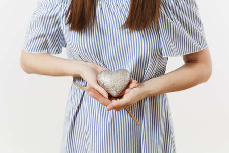 Young tender elegant woman in blue dress holding silver heart isolated on white background. People, charity, health care, donation, medicine concept, lifestyle concept. Advertising area. Copy spaceの写真素材