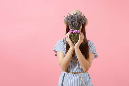 Portrait of a happy young tender woman in blue dress, hat holding bouquet of beautiful purple lavender flowers isolated on bright trending pink background. International Women's Day holiday conceptの写真素材