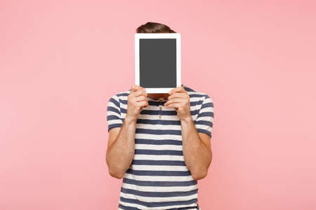 Portrait of young man holding tablet computer with blank black empty screen display touchscreen copy...