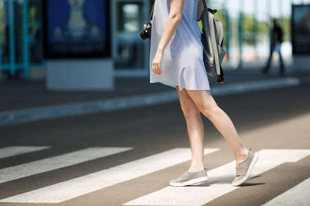 Cropped Young traveler tourist woman in light clothes with backpack standing on crosswalk at international airport. Female passenger traveling to travel abroad on weekends getaway. Air flight conceptの写真素材