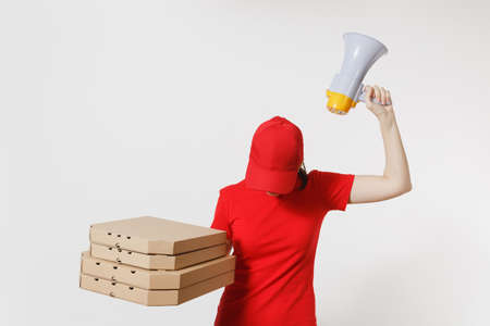 Woman in red cap, t-shirt bowed head, giving food order pizza boxes isolated on white background. Female courier screaming in megaphone, holding italian pizza in cardboard flatbox. Delivery conceptの写真素材