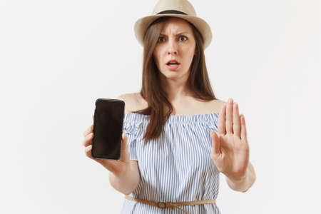 Young woman showing stop gesture with palm, showing to camera mobile phone with blank black empty screen isolated on white background. People sincere emotions concept. Advertising area. Copy spaceの写真素材