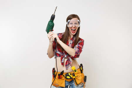 Strong young energy handyman woman in plaid top shirt denim shorts kit tools belt full of...