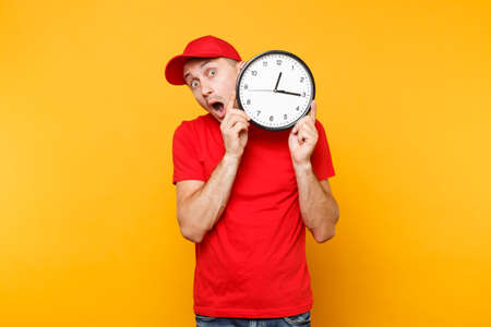 Delivery man in red uniform isolated on yellow orange background. Professional smiling male employee...