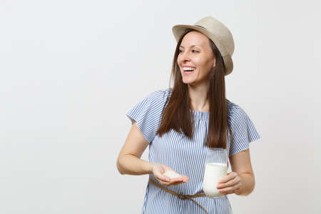Young smiling woman in dress hold in hands rice milk in glass, handful of rice isolated on white background. Proper nutrition, vegan vegetarian drink, healthy lifestyle dieting concept. Copy spaceの写真素材
