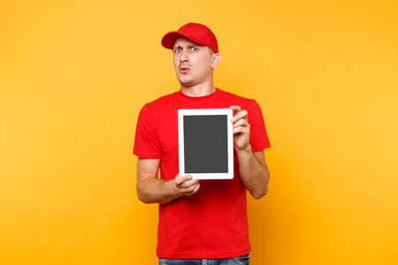 Delivery man isolated on yellow orange background. Professional male employee courier in red cap,...