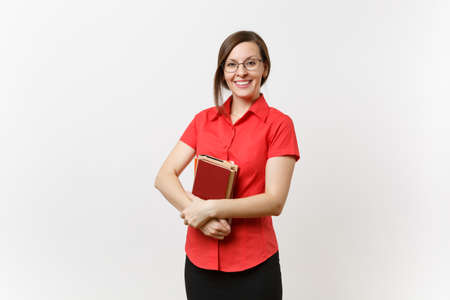 Portrait of beautiful young business teacher woman in red shirt, black skirt and glasses holding books in hands isolated on white background. Education or teaching in high school university conceptの写真素材