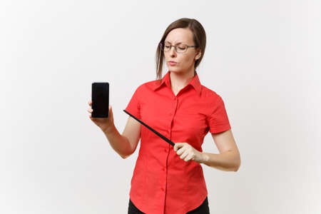 Strict severe serious teacher woman user in red shirt hold mobile smart phone with blank empty screen to copy space isolated on white background. Education teaching in high school university conceptの写真素材