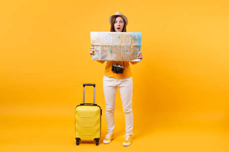Traveler tourist woman in summer casual clothes, hat with suitcase, city map isolated on yellow...