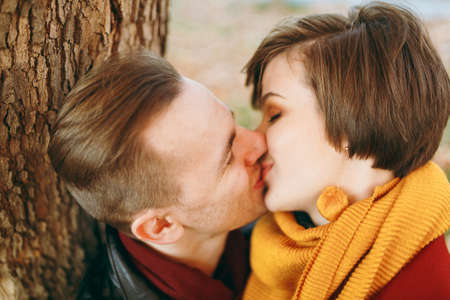 Portrait of Young happy beautiful couple in love smiling woman man with closed eyes kissing in...