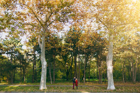 Young beautiful couple in love, happy woman and man in casual warm clothes holding hands looking at...