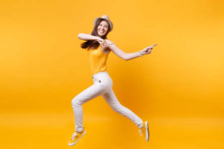 Portrait of excited smiling young happy jumping high woman in straw summer hat, copy space isolated...