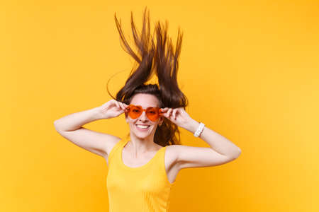 Portrait of excited cheerful laughter funny comic woman in orange glasses with fluttering hair copy...