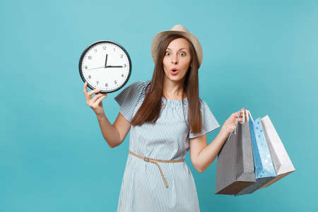 Portrait beautiful young caucasian woman in summer dress, straw hat holding packages bags with...