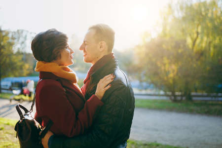 Portrait of young couple in love woman man in casual warm clothes embracing hugging looking at each...