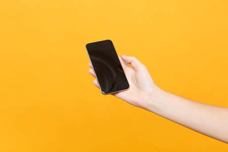 Close up female hold in hand mobile phone with blank empty screen with place for text or image,...