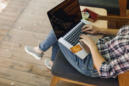 Close up cropped girl in outdoors street coffee shop wooden cafe sitting working on laptop pc...