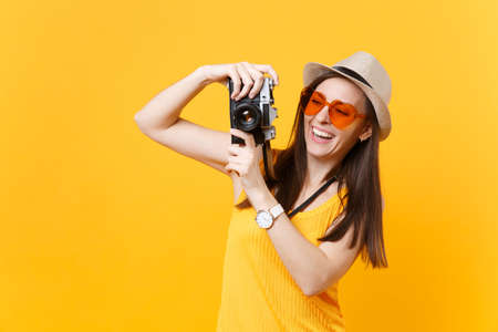 Tourist woman in summer casual clothes, hat take picture on retro vintage photo camera isolated on...