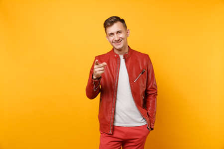 Portrait vogue smiling handsome young man 25-30 years in red leather jacket, t-shirt standing isolated on bright trending yellow background. People sincere emotions lifestyle concept. Advertising areaの写真素材