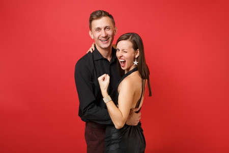 Fashionable young couple in black clothes shirt dress celebrating birthday holiday party isolated on bright red background. St. Valentine International Women Day Happy New Year 2019 concept. Mock upの写真素材