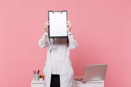 Cute female doctor stand in front of desk with pc computer, medical document in hospital isolated on...