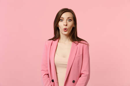Portrait of shocked amazed young woman wearing jacket looking camera, keeping mouth open isolated on...