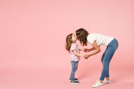 Woman in light clothes have fun with cute child baby girl. Mother, little kid daughter isolated on...