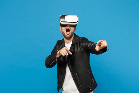Stylish young unshaven man in black jacket white t-shirt looking in headset, virtual vr reality...