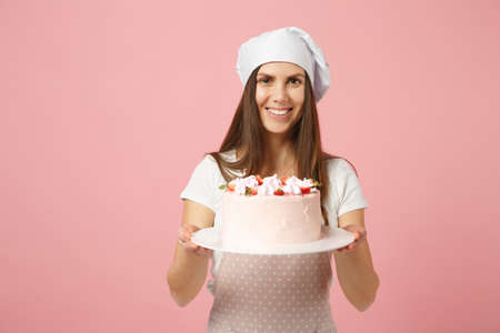 Housewife female chef cook confectioner or baker in apron white t-shirt, toque chefs hat hold in...