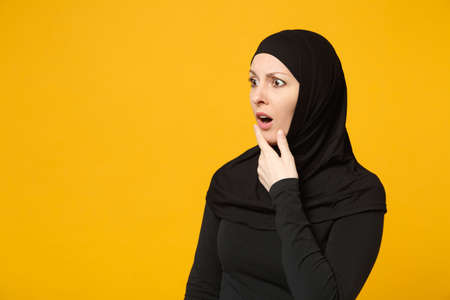 Sad upset crying confused young arabian muslim woman in hijab black clothes posing isolated on...