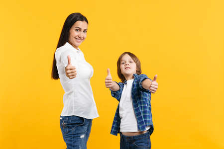 Smiling woman in casual clothes have fun with child boy. Mother, little kid son showing thumbs up...