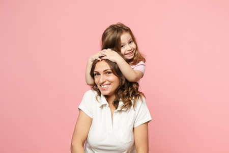 Woman in light clothes have fun with cute child baby girl. Mother, little kid daughter isolated on pastel pink wall background, studio portrait. Mother's Day love family, parenthood childhood conceptの写真素材