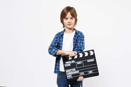 Fun little kid boy in blue t-shirt hold in hand classic black film making clapperboard isolated on...