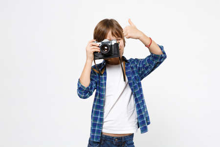 Fun little kid boy in blue t-shirt hold retro vintage photo camera, doing photo shot isolated on white wall background children studio portrait. People childhood lifestyle concept. Mock up copy space.の写真素材