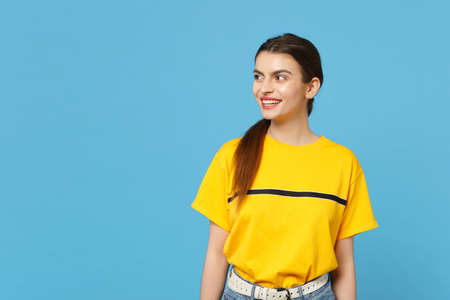 Portrait of cheerful smiling beautiful young woman in vivid casual clothes standing and looking...