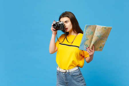 Attractive young woman in vivid casual clothes take pictures on retro vintage photo camera hold...