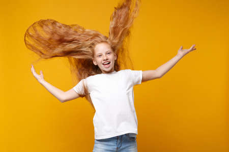 Cheerful little ginger kid girl 12-13 years old in white t-shirt isolated on yellow background...