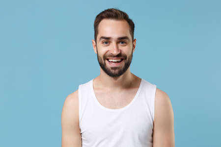 Close up bearded young man 20s years old perfect skin wearing white shirt isolated on blue pastel wall background, studio portrait. Skin care healthcare cosmetic procedures concept. Mock up copy spaceの写真素材