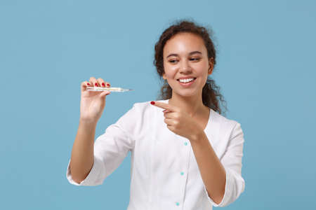 Smiling african american female doctor woman in white medical gown point finger on clinical...