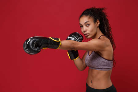Side view of beautiful african american sports fitness boxer woman in sportswear work out isolated...