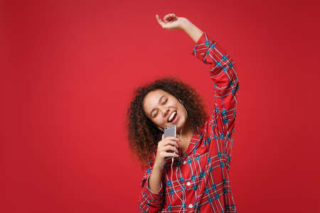Young african american girl in pajamas homewear resting at home isolated on red background. Relax...
