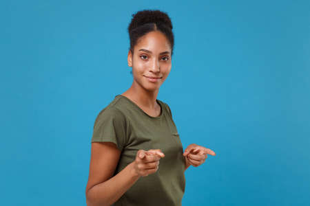Smiling young african american woman girl in casual t-shirt posing isolated on blue background...