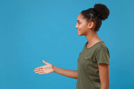 Side view of young african american woman girl in casual t-shirt posing isolated on bright blue...