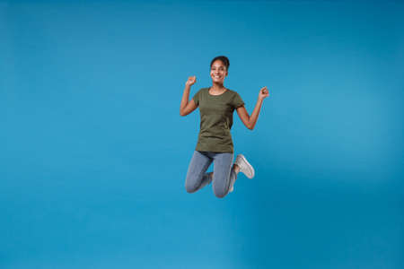 Smiling young african american woman girl in casual clothes posing isolated on bright blue...